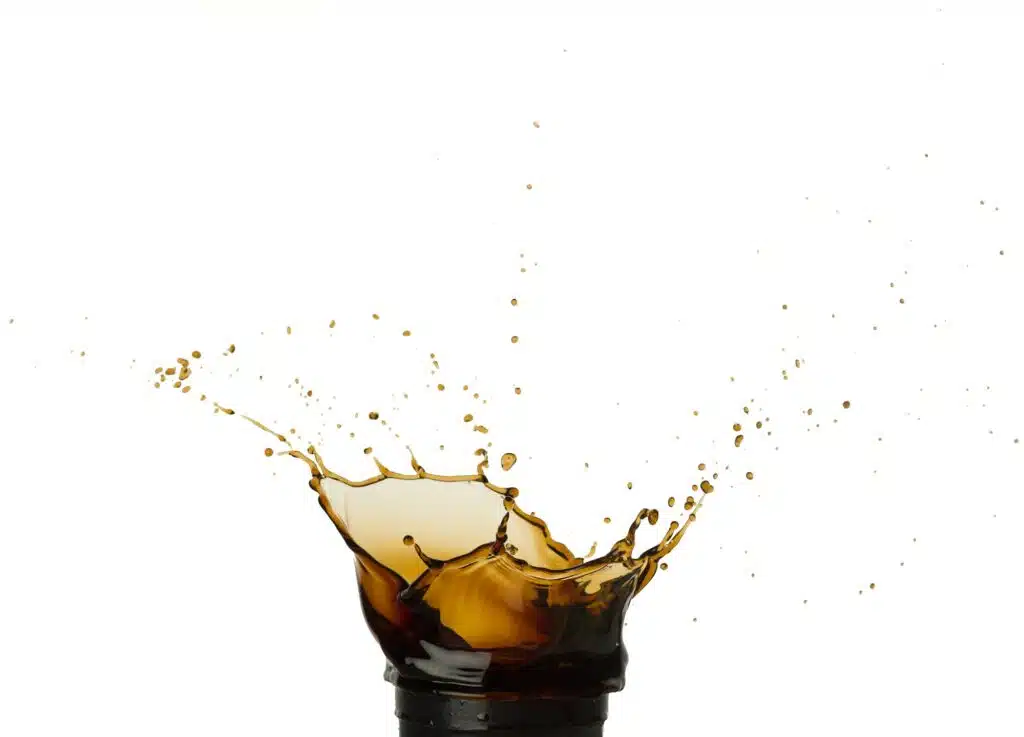 Splashing coffee or cola to go leaning on white background.